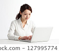 Portrait of a young female business person working on a computer against a white background 127995774