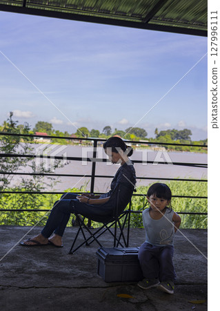 Toddler Sits Waiting For His Mother Who Is Playing On Phone, Background for advertising and wallpaper in education and lifestyle scene. 127996111