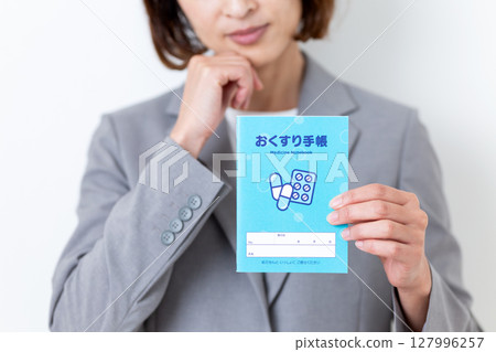 一位身穿灰色西裝的中年婦女擔心她的藥本 127996257