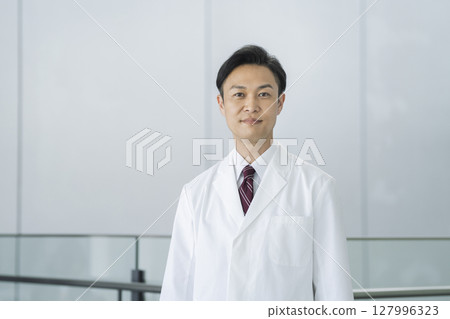 Male doctor/researcher in his 40s wearing a white coat, looking at camera 127996323