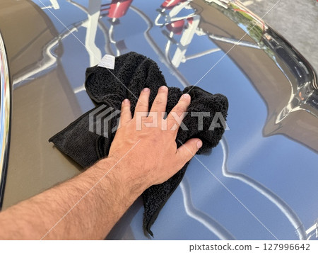 Man hand cleaning car with microfiber cloth at car wash 127996642