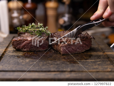 Steak on cutting board, garnished with fresh thyme 127997822