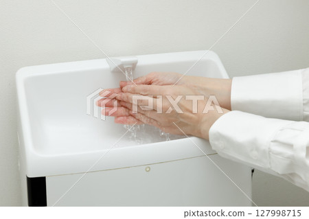 Woman washing her hands in the bathroom Woman washing her hands in the bathroom 127998715