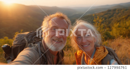 Adventurous Senior Couple's Mountain Summit Selfie: Celebrating Active Retirement and Outdoor Exploration with Breathtaking Sunset Views 127998761