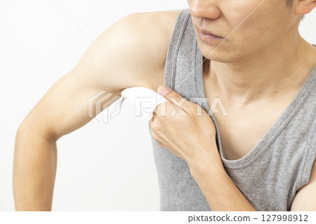 Man using sweat wipes on white background Man using sweat wipes on white background 127998912