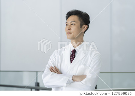 一名 40 多歲、身穿白大褂、雙臂交叉的男子的照片，醫生/研究員 127999055