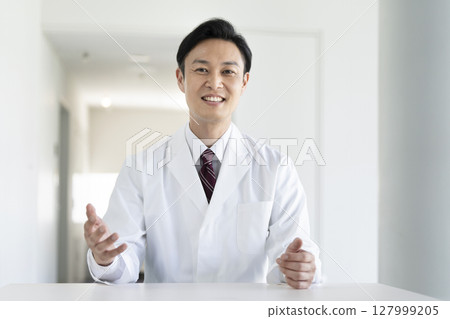 A man in his 40s wearing a white coat talking to the camera, doctor/researcher image A man in his 40s wearing a white coat talking to the camera, doctor/researcher image 127999205
