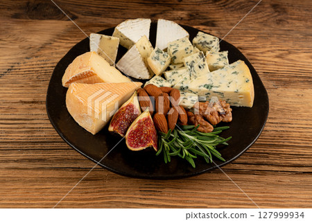 Cheese plate of color cheeses variety, yellow, white and blue cheese board, assorted dairy products Cheese plate of color cheeses variety, yellow, white and blue cheese board, assorted dairy products 127999934