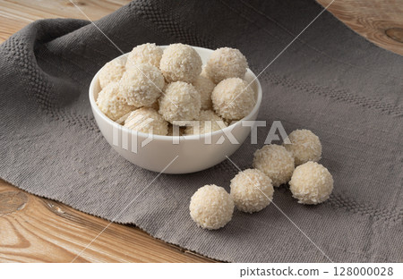 Coconut candies pile, coco ball. White truffle ball, indian ladoo or laddu with sweet cream and coco Coconut candies pile, coco ball. White truffle ball, indian ladoo or laddu with sweet cream and coco 128000028