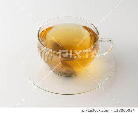 Herbal tea sachet in cup, hot water with chamomile and Hypericum or St. John's wort teabag Herbal tea sachet in cup, hot water with chamomile and Hypericum or St. John's wort teabag 128000084