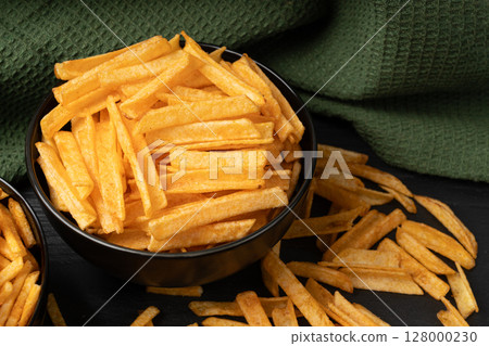 Fried chips sticks, finger potato chips, golden shoestring fries pile, French fries 128000230
