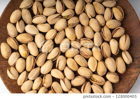 Fried salt pistachio nuts texture background. Baked pistachios pattern, roasted green pistache 128000403