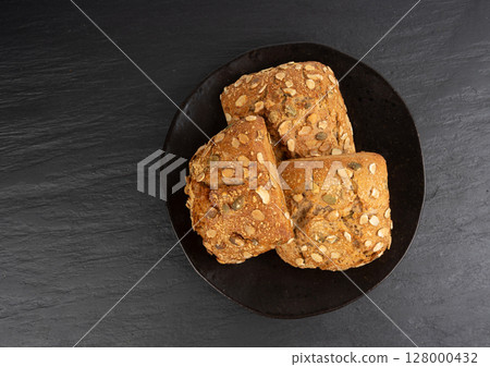 Pumpkin seeds bread, breakfast roll with pepita seeds. Fitness square bun, healthy burger 128000432