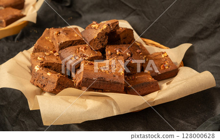 Brownie pile on paper. Chocolate cakes stack, homemade square dessert with fudge Brownie pile on paper. Chocolate cakes stack, homemade square dessert with fudge 128000628