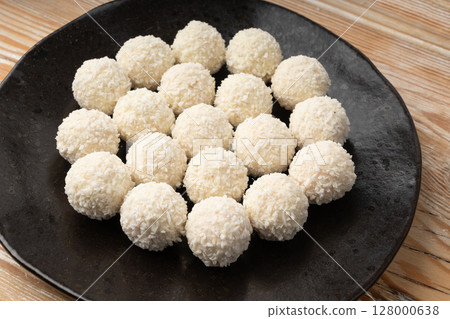 Coconut candies pile, coco ball. White truffle ball, indian ladoo or laddu with sweet cream and coco Coconut candies pile, coco ball. White truffle ball, indian ladoo or laddu with sweet cream and coco 128000638