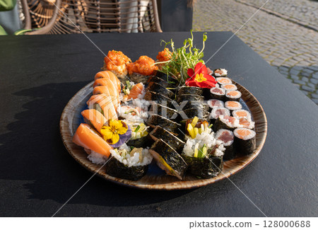 Colorful Japanese Sushi Platter with Variety of Rolls and Edible Flowers Colorful Japanese Sushi Platter with Variety of Rolls and Edible Flowers 128000688