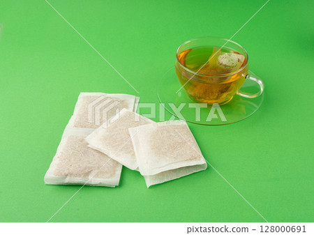 Herbal tea sachet in cup, hot water with chamomile and Hypericum or St. John's wort teabag Herbal tea sachet in cup, hot water with chamomile and Hypericum or St. John's wort teabag 128000691
