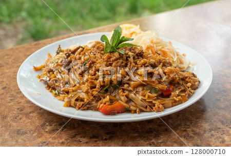 Pad thai or phad tha asian noodles closeup. Chinese rice pasta, phat thai with meat, noodles Pad thai or phad tha asian noodles closeup. Chinese rice pasta, phat thai with meat, noodles 128000710