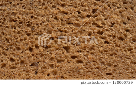 Bread slice macro texture, baked dough pattern. Brown bread loaf cut close up, wheat toast slice Bread slice macro texture, baked dough pattern. Brown bread loaf cut close up, wheat toast slice 128000729