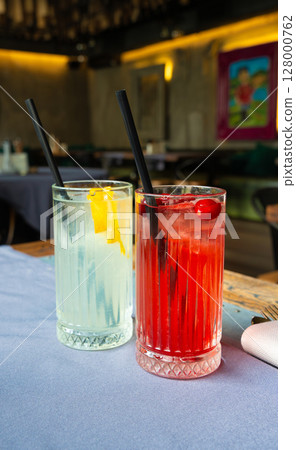 Cold lingonberry drink on restaurant table. Iced cowberry tea, refreshing cranberry cocktail 128000762
