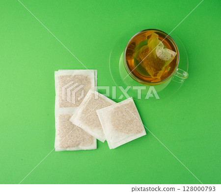 Herbal tea sachet in cup, hot water with chamomile and Hypericum or St. John's wort teabag 128000793