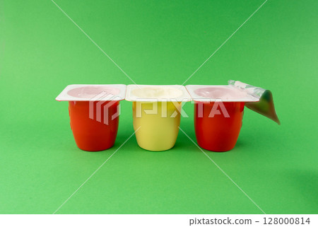 Yogurt cups set, pink and yellow fruit yoghurt in plastic pots, milk pudding container with spoon Yogurt cups set, pink and yellow fruit yoghurt in plastic pots, milk pudding container with spoon 128000814