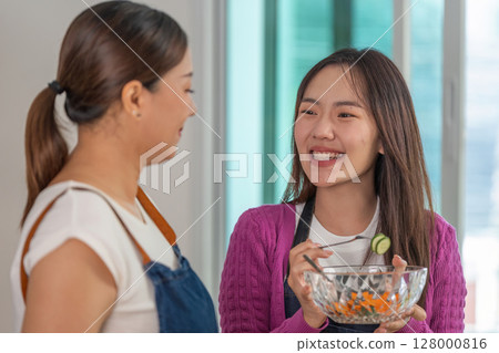Healthy Cooking Together. Woman sharing a meal preparation moment with a friend. Healthy Cooking Together. Woman sharing a meal preparation moment with a friend. 128000816