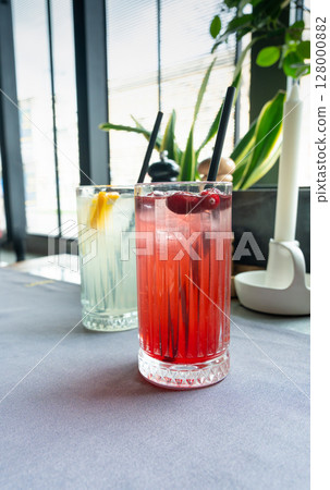 Cold lingonberry drink on restaurant table. Iced cowberry tea, refreshing cranberry cocktail Cold lingonberry drink on restaurant table. Iced cowberry tea, refreshing cranberry cocktail 128000882