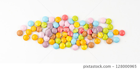 Scattered small candies isolated. Colorful dragees, multicolored glazed chocolate buttons Scattered small candies isolated. Colorful dragees, multicolored glazed chocolate buttons 128000965