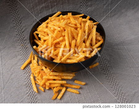 Fried chips sticks, finger potato chips, golden shoestring fries pile, French fries Fried chips sticks, finger potato chips, golden shoestring fries pile, French fries 128001023