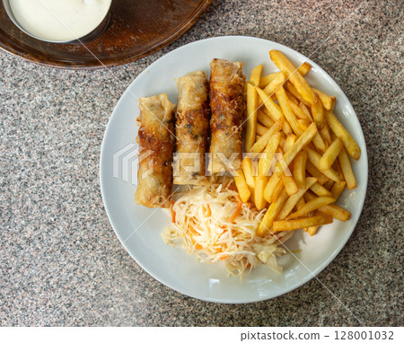 Fried spring rolls. Crispy springrolls, roasted egg rolls with French fries and Vietnamese sauces Fried spring rolls. Crispy springrolls, roasted egg rolls with French fries and Vietnamese sauces 128001032