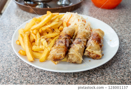 Fried spring rolls. Crispy springrolls, roasted egg rolls with French fries and Vietnamese sauces Fried spring rolls. Crispy springrolls, roasted egg rolls with French fries and Vietnamese sauces 128001137