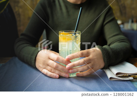 Ice lemonade in tall glass. Yuzu mocktail with lemon and soda, cool lime juice cocktail Ice lemonade in tall glass. Yuzu mocktail with lemon and soda, cool lime juice cocktail 128001162