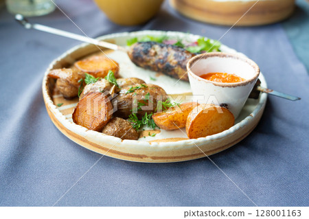 Georgian lula kebab plate. Bbq skewer, traditional barbecue dish with baked potatoes, sauce Georgian lula kebab plate. Bbq skewer, traditional barbecue dish with baked potatoes, sauce 128001163
