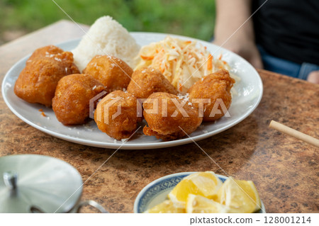 Fried chicken balls with rice and fresh cabbage salad closeup. Deep fried dough balls 128001214