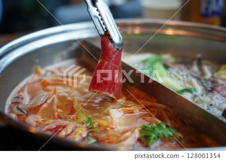 Hot Pot with Thinly Sliced Meat and Fresh Vegetables. Close-Up of Cooking Moment 128001354