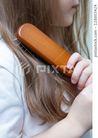Young woman with long, dark blonde hair pulled back in a low ponytail. Casual hairstyle. Sporty hairstyle. Running hairstyle. Young woman with long, dark blonde hair pulled back in a low ponytail. Casual hairstyle. Sporty hairstyle. Running hairstyle. 128003424