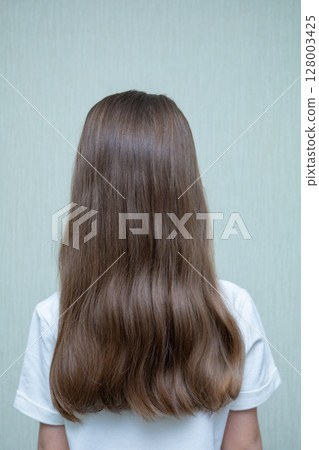 Rear view of little girl in floral dress looking at wall. Isolated on white background Rear view of little girl in floral dress looking at wall. Isolated on white background 128003425