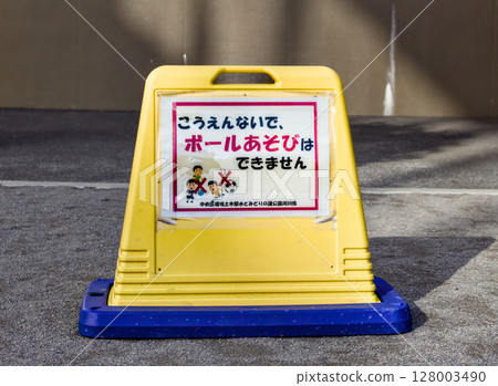 There is a sign posted in the park saying that ball games are not allowed. 128003490
