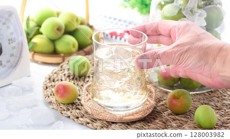 Homemade plum juice and preserved green plums in a jar. Refreshing summer drink photo (plum syrup) Homemade plum juice and preserved green plums in a jar. Refreshing summer drink photo (plum syrup) 128003982