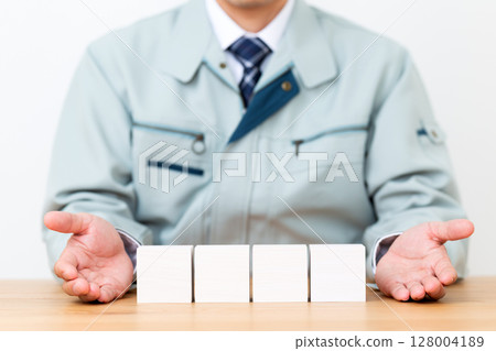中年男性商人穿著工作服，拿著一塊 128004189