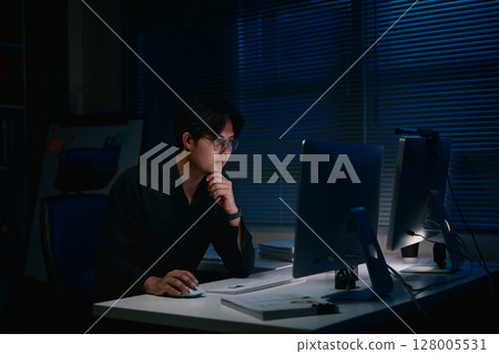 Businessman working alone late at night, feeling stressed and exhausted Businessman working alone late at night, feeling stressed and exhausted 128005531