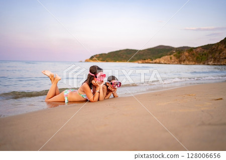 Family enjoys a fun day at the beach while exploring the waves 128006656