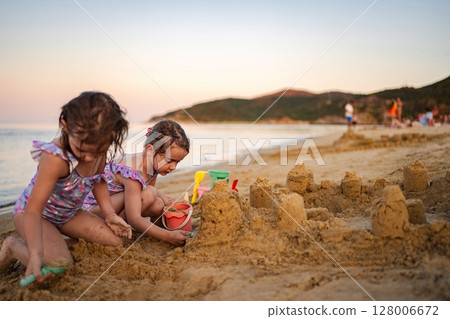 Sunset beach fun: building sandcastles with family 128006672