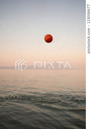 Family enjoys sunset at the beach playing with a vibrant basketball Family enjoys sunset at the beach playing with a vibrant basketball 128006677