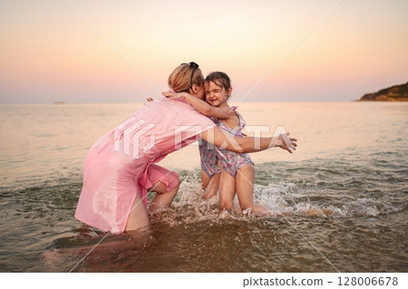 Joyful family moments at the beach during sunset Joyful family moments at the beach during sunset 128006678
