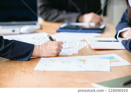 Hands in an office meeting Hands in an office meeting 128006920