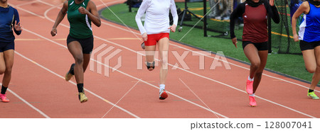 Five High School Girls Sprinting on a Track During a Competitive Race Five High School Girls Sprinting on a Track During a Competitive Race 128007041