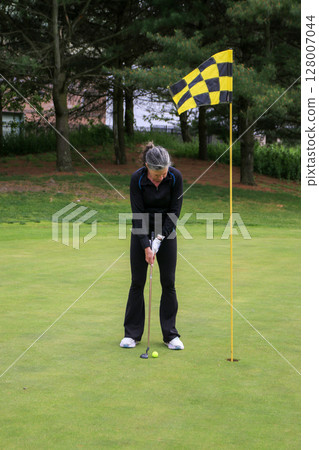 Golfer Preparing to Make a Putt 128007044
