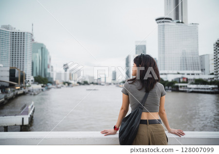Solo southeast asian woman teenager blogger express thoughtful wait for local boat. world travel explorer cultural experience on Chao Phraya river. Asia tourism concept in Bangkok Thailand Solo southeast asian woman teenager blogger express thoughtful wait for local boat. world travel explorer cultural experience on Chao Phraya river. Asia tourism concept in Bangkok Thailand 128007099